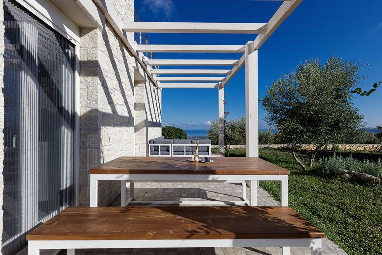 Dining area under the Villa Eos pergola with a sea view