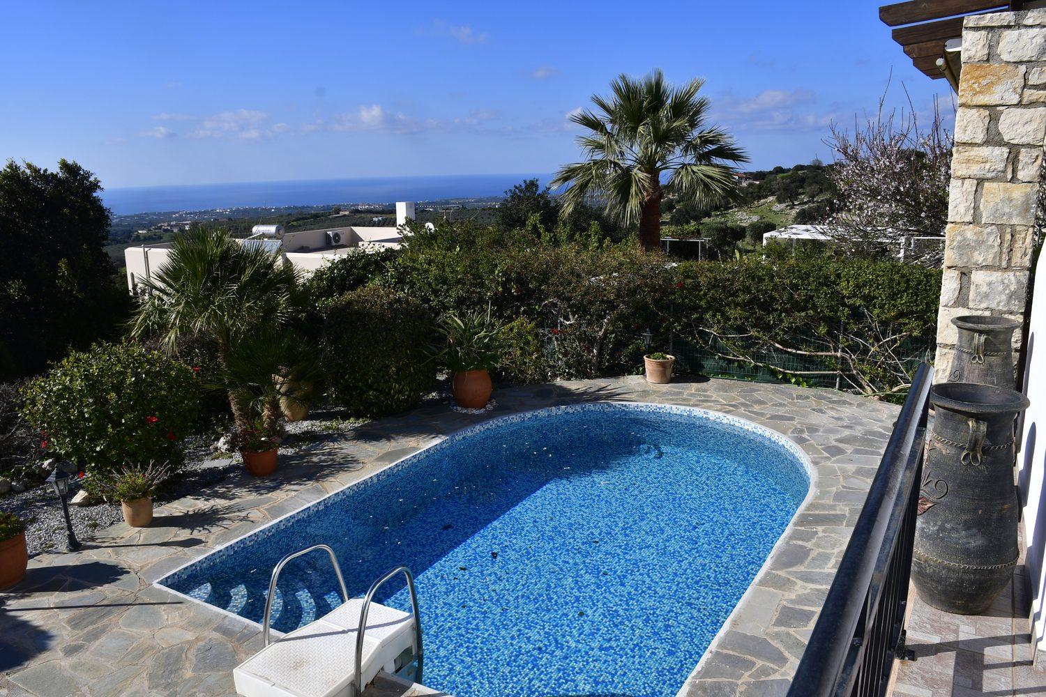 Villa Mailin pool with palm tree, stone wall and a view over the surroundings